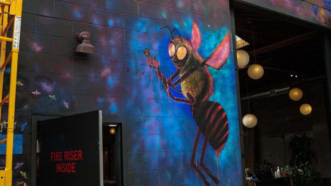 Finished bee character mural on the side of a building