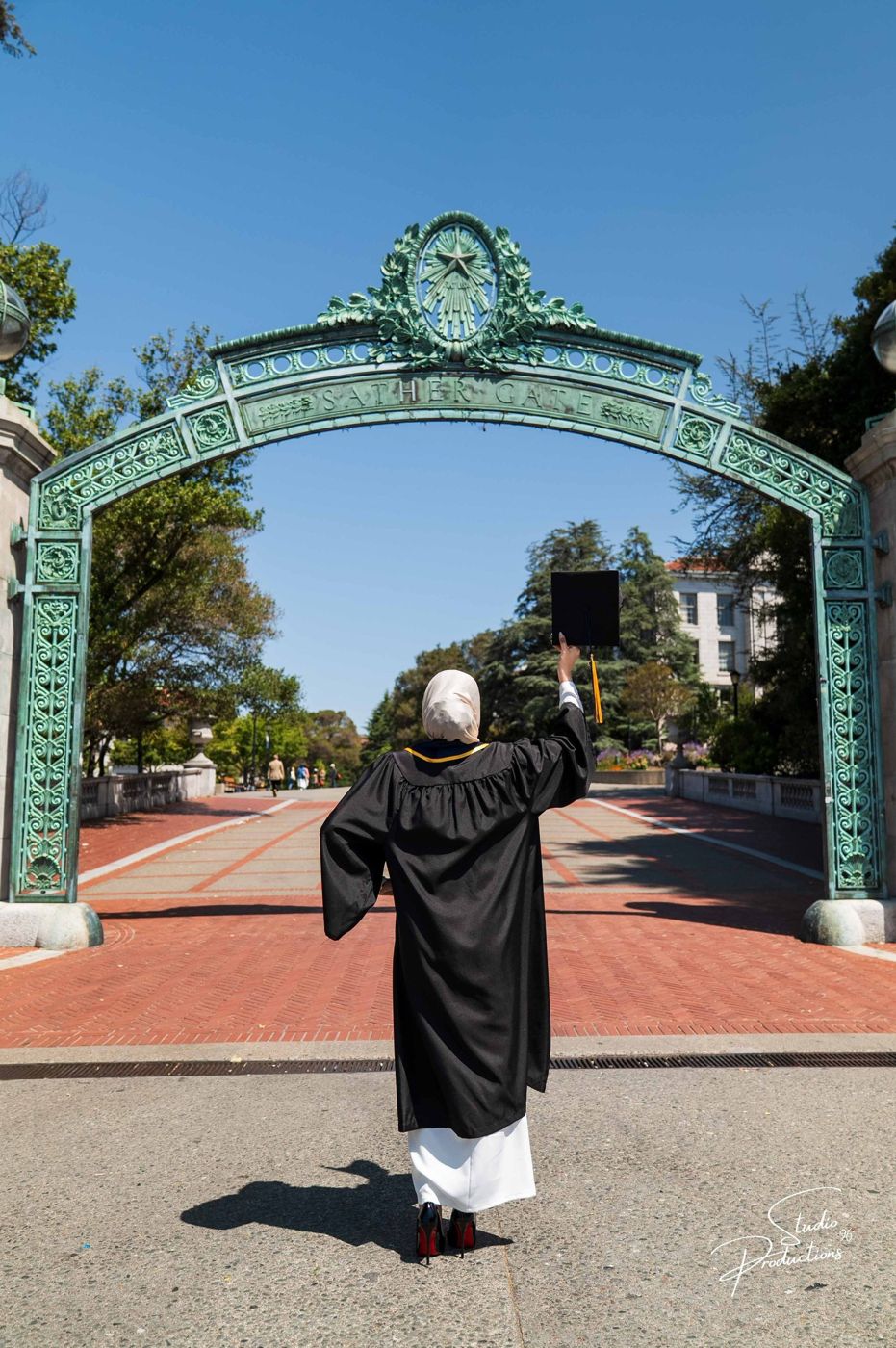 Graduate walking beneath UC Berkeley's Sather Gate