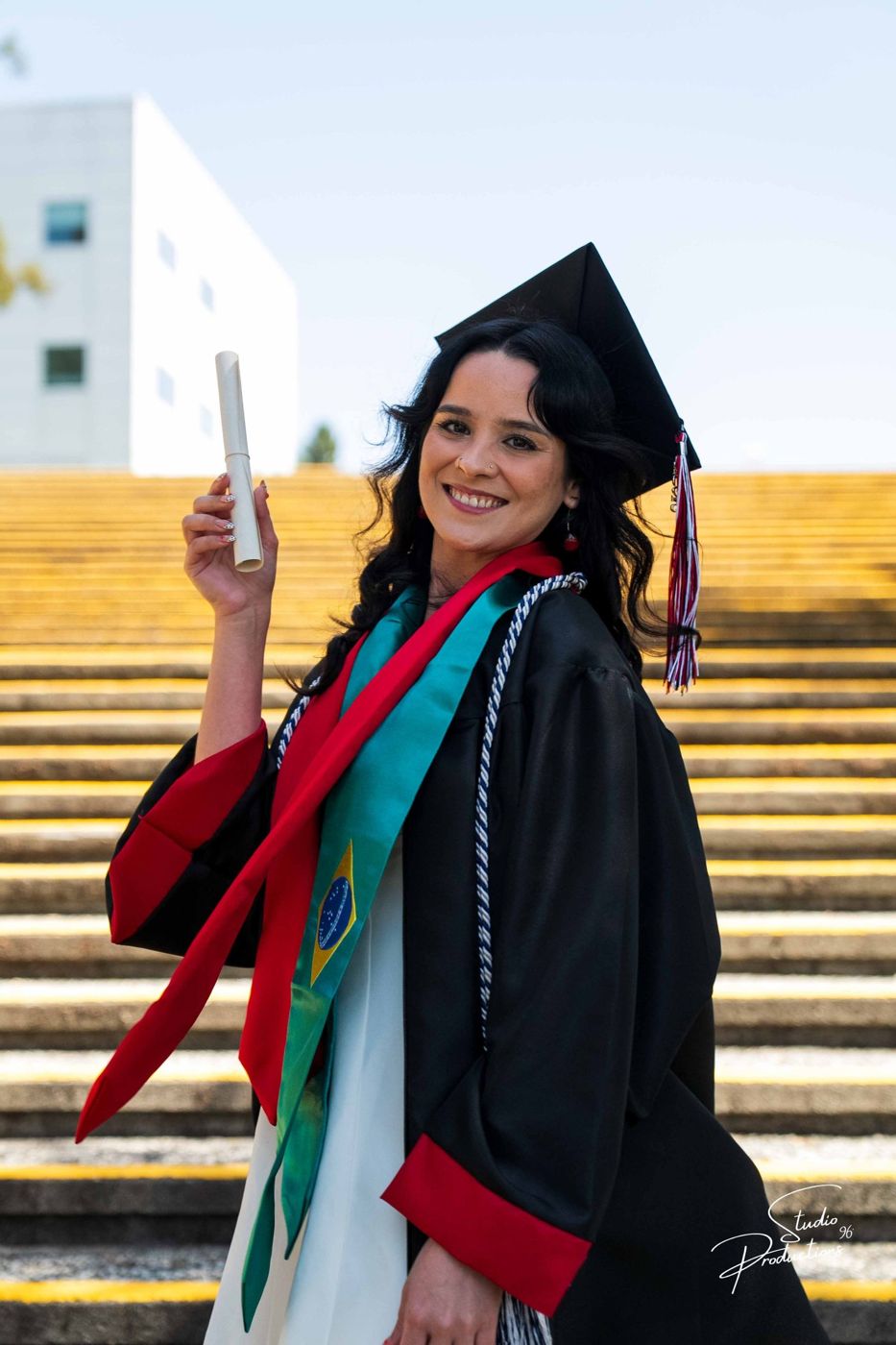 Graduate celebrating with a raised diploma