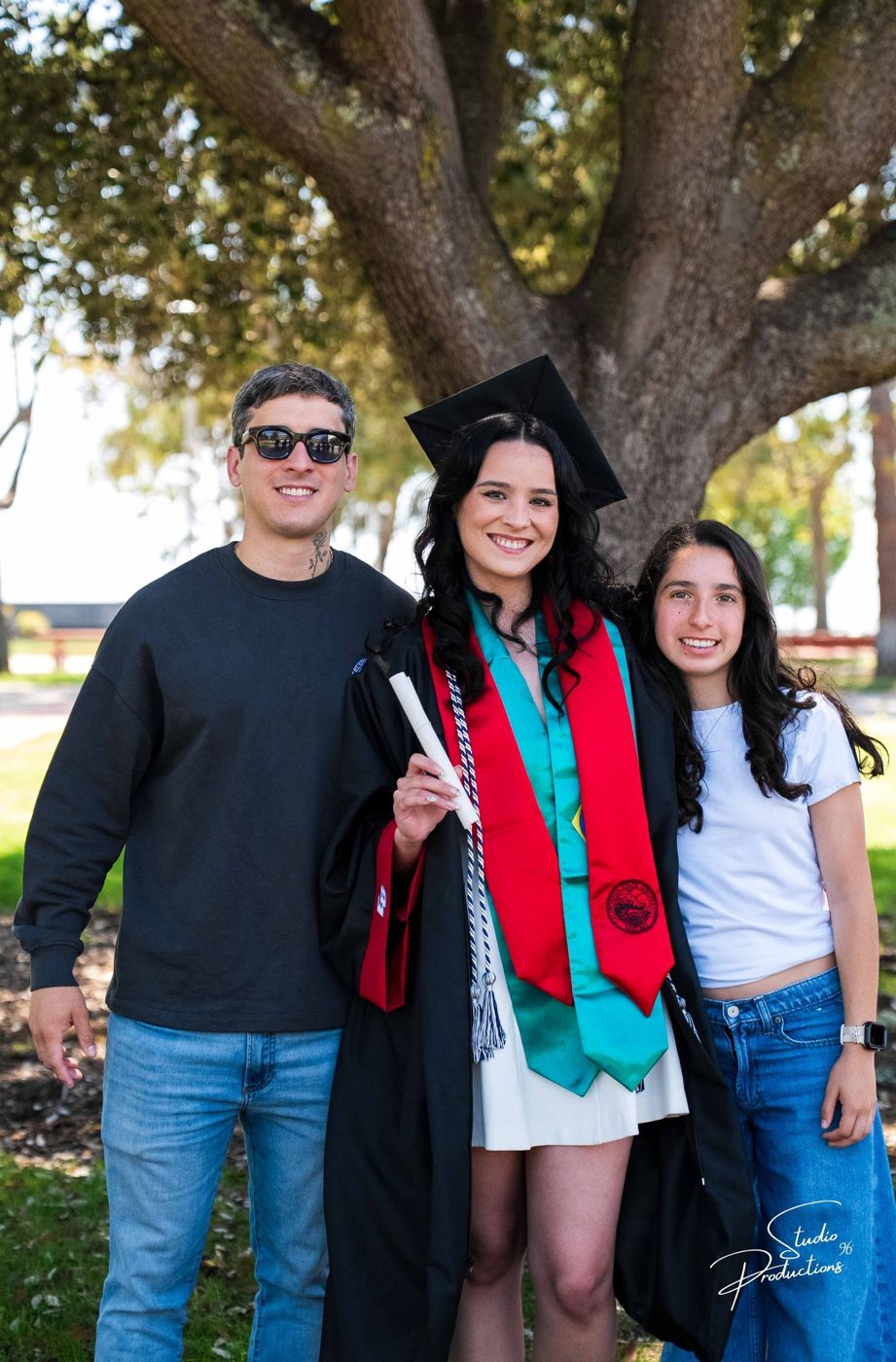 Portrait of the graduate posing with two family members