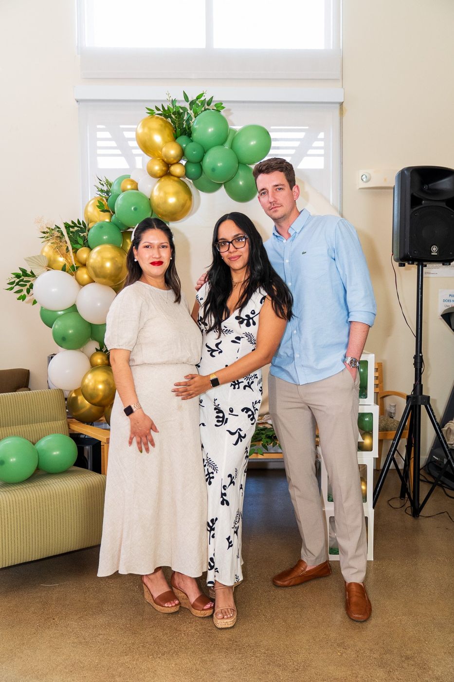 Mom-to-be posing candidly with two guests at the party