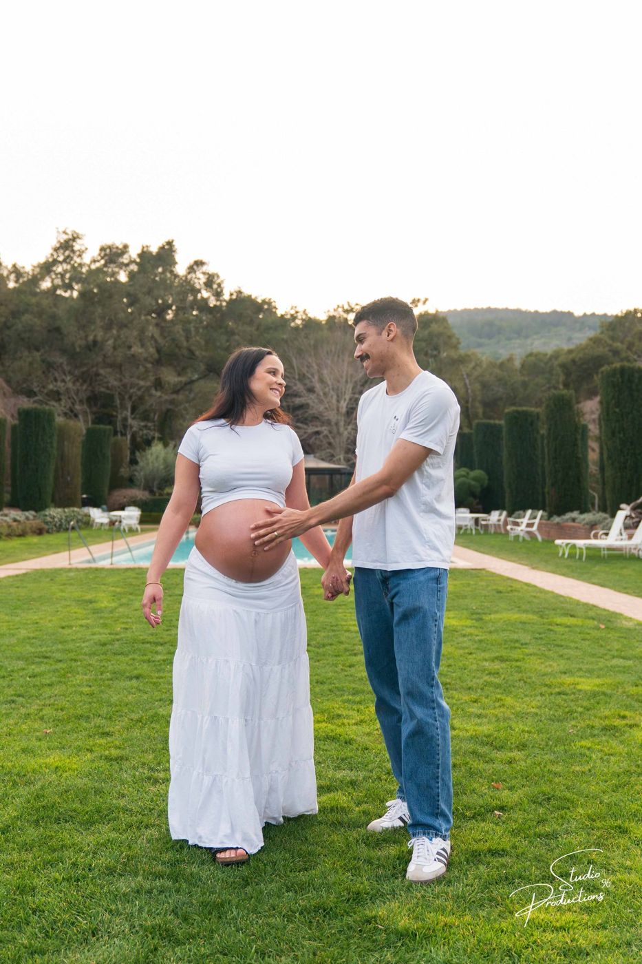 The couple laughing together, walking hand in hand toward the pool
