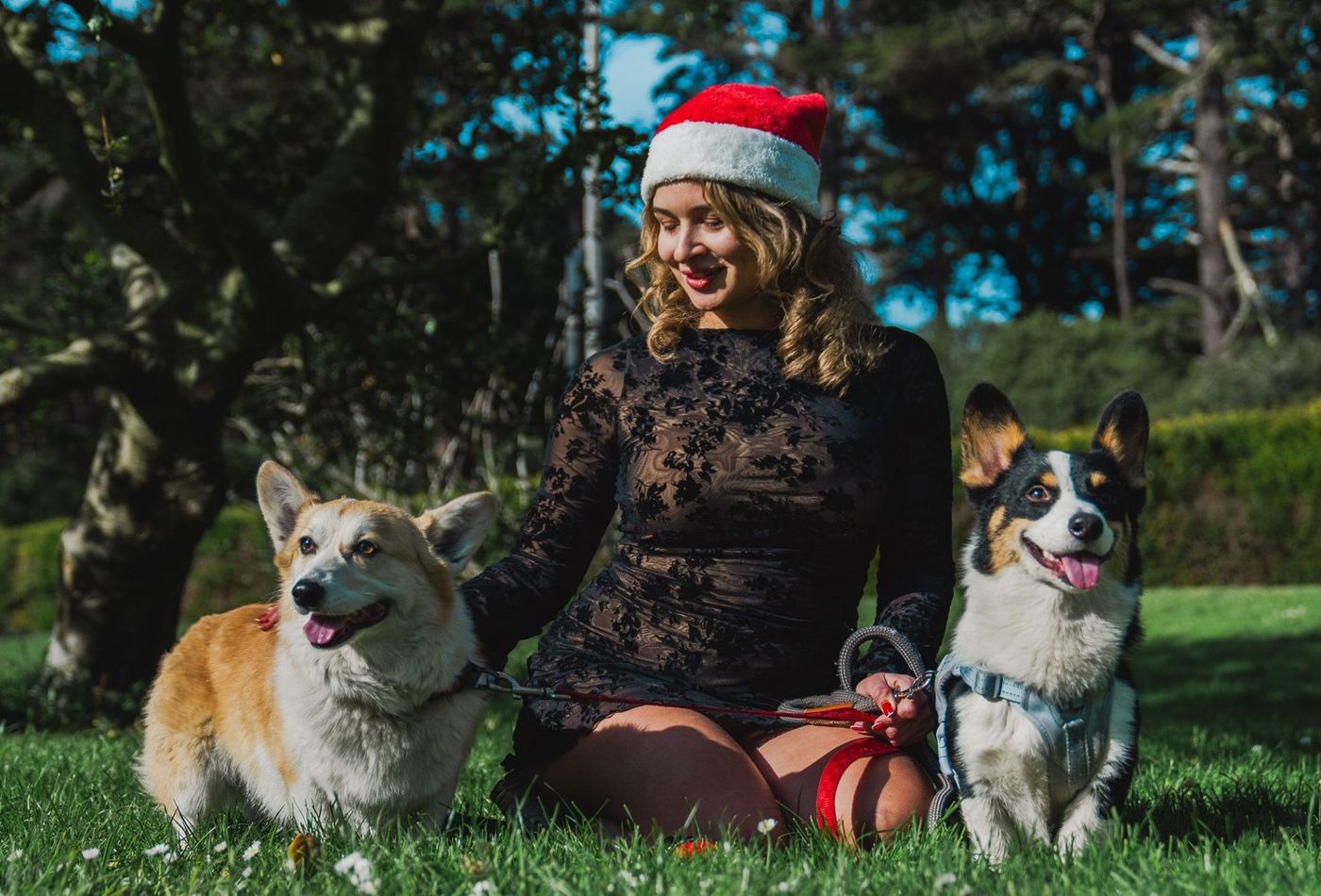 Woman sitting together with both corgis in a candid moment
