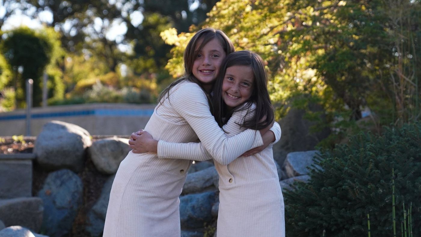 Two sisters sharing a warm hug in the garden