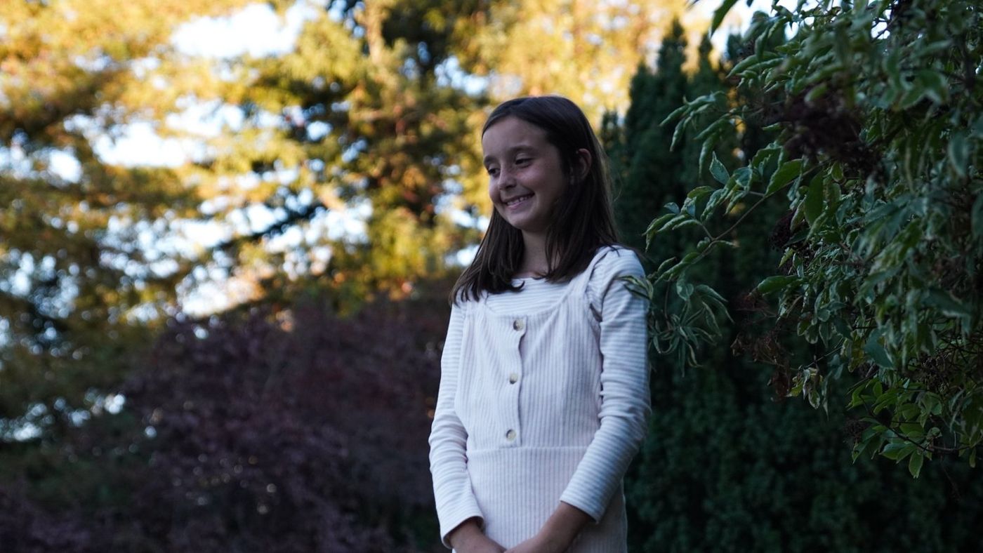 Solo portrait of one daughter standing outdoors near a pond
