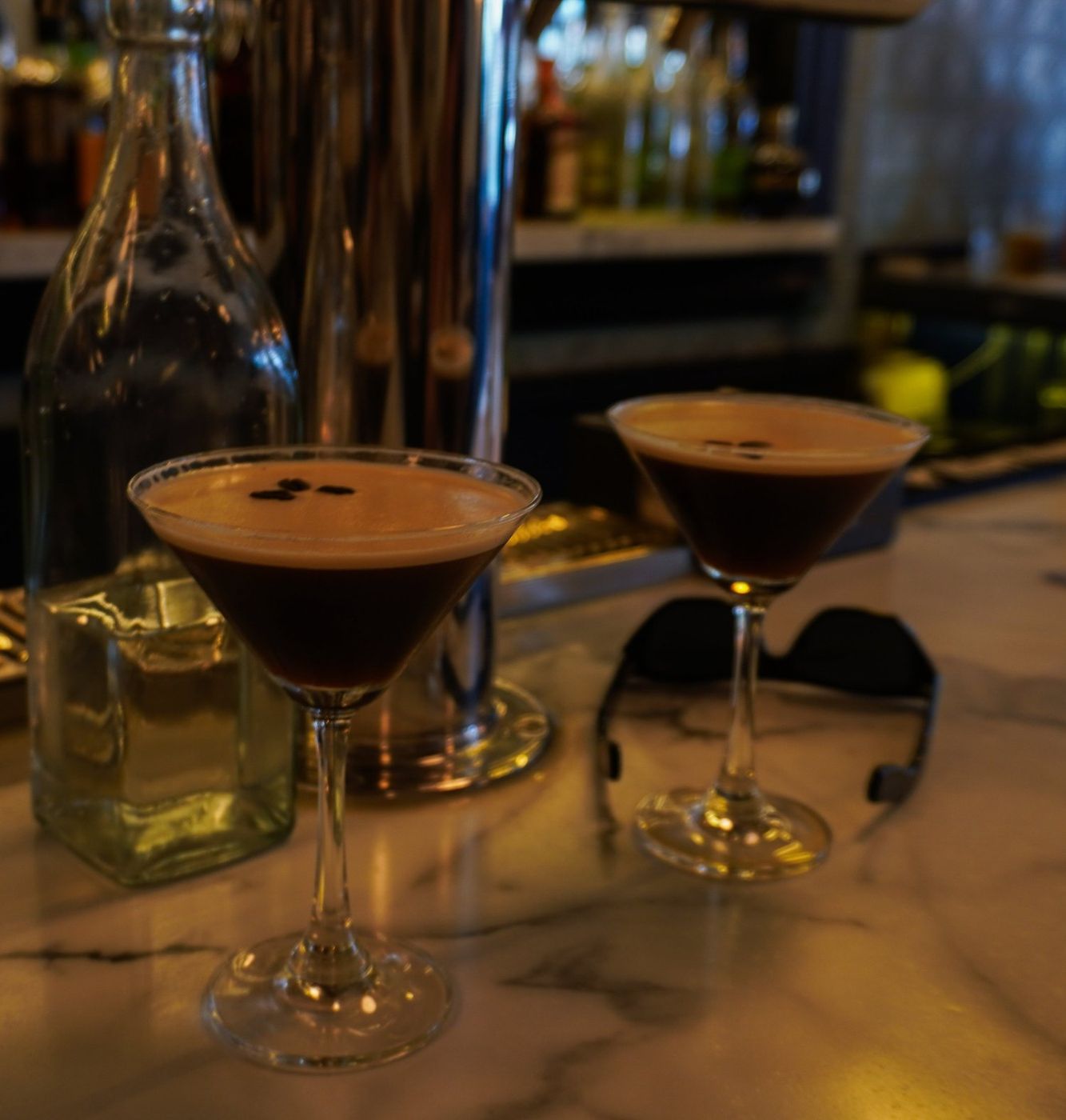 Two espresso martinis served at a bar