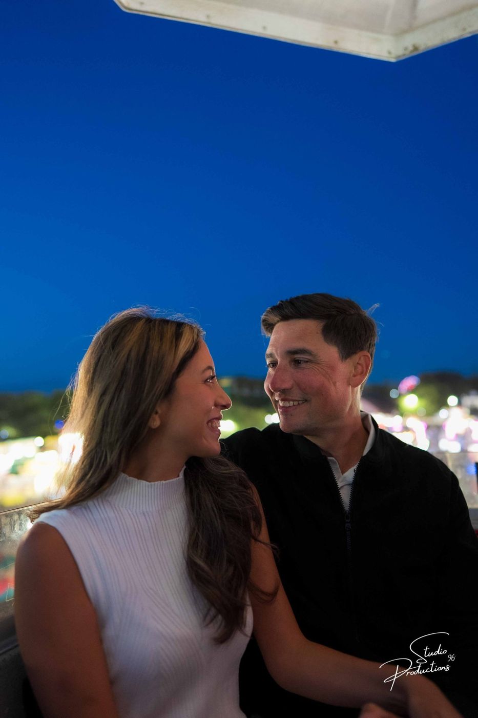Close portrait of the couple in blue-hour light at the fairgrounds