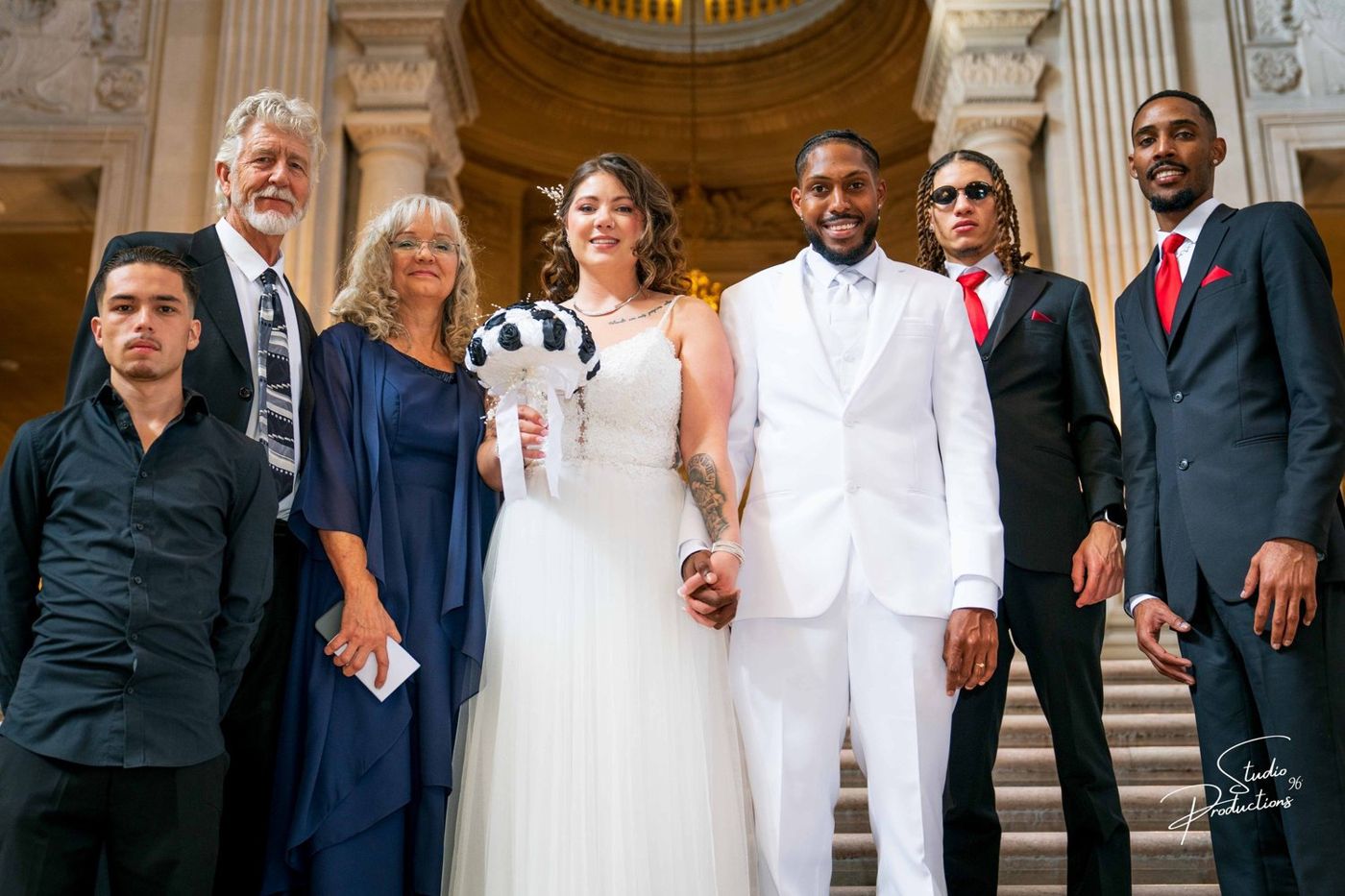 Guests and wedding party posing together on the staircase