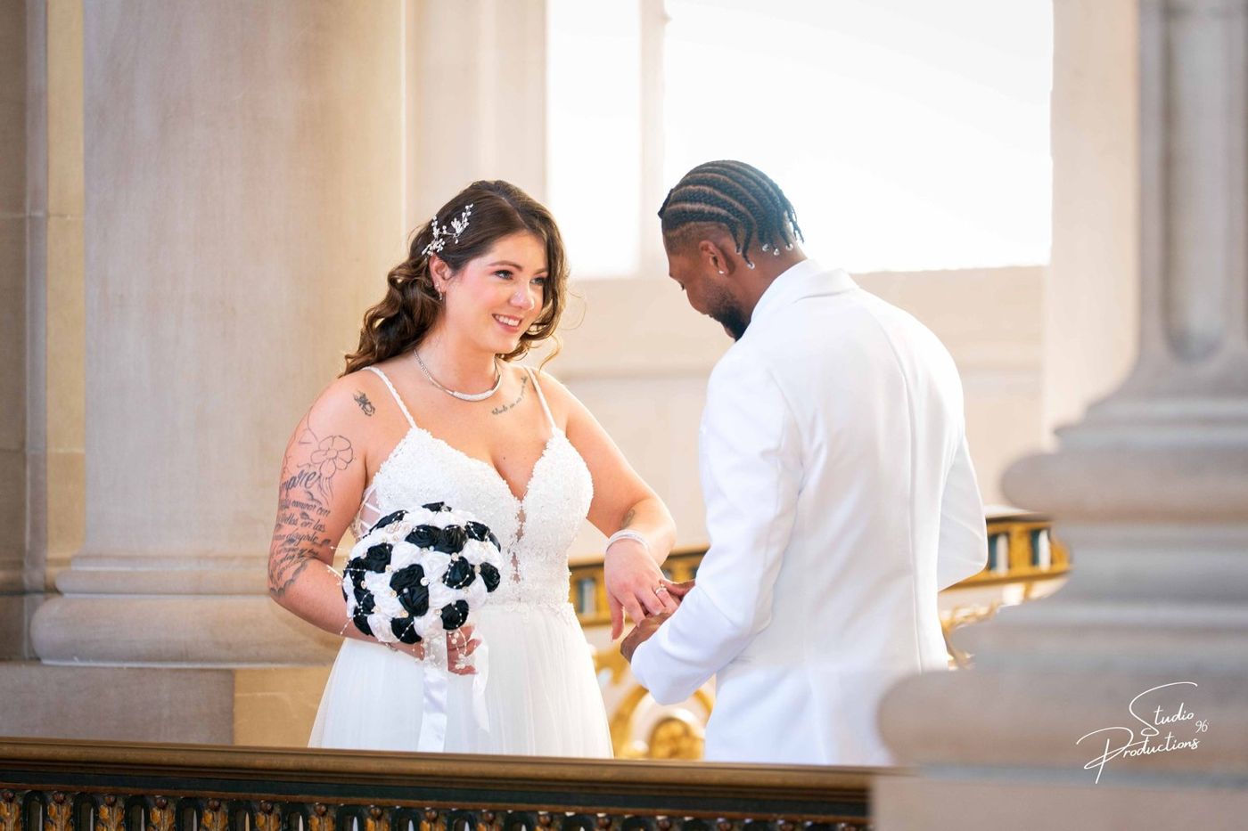 A tender moment as the bride adjusts the groom's white head covering