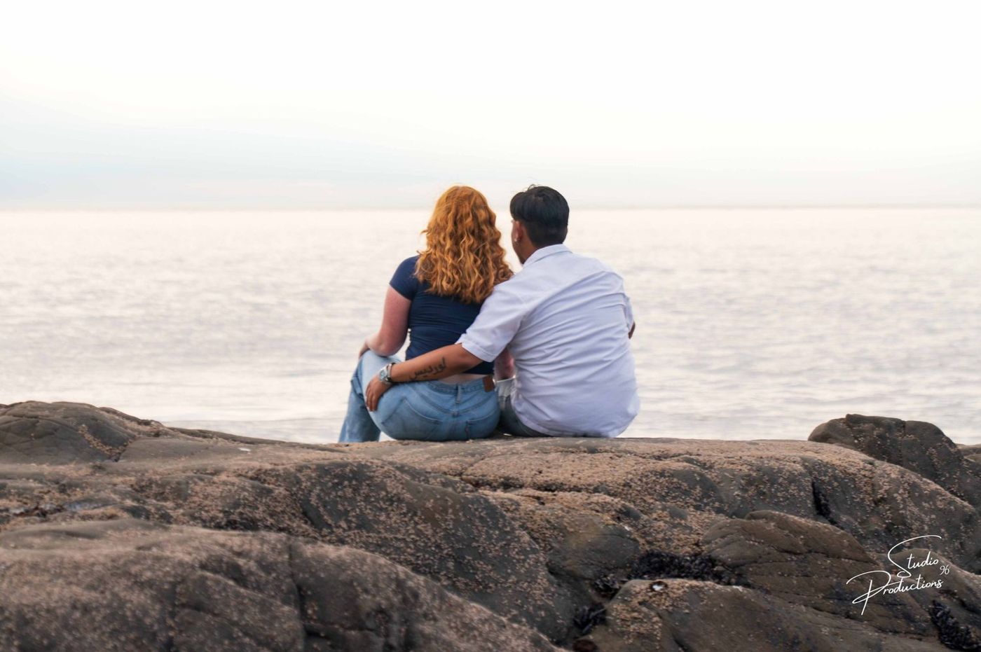The couple sitting together looking out at the ocean